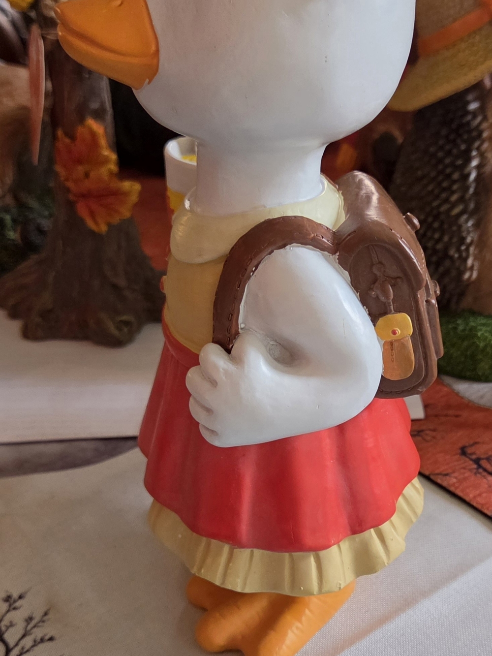 Decorative White Duck Figurine with Red Skirt and Brown Backpack